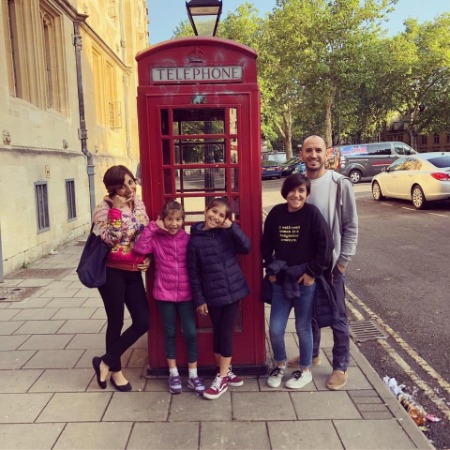 Mehrsa Baradaran and Jared Bybee with their daughters in front of the telephone booth.